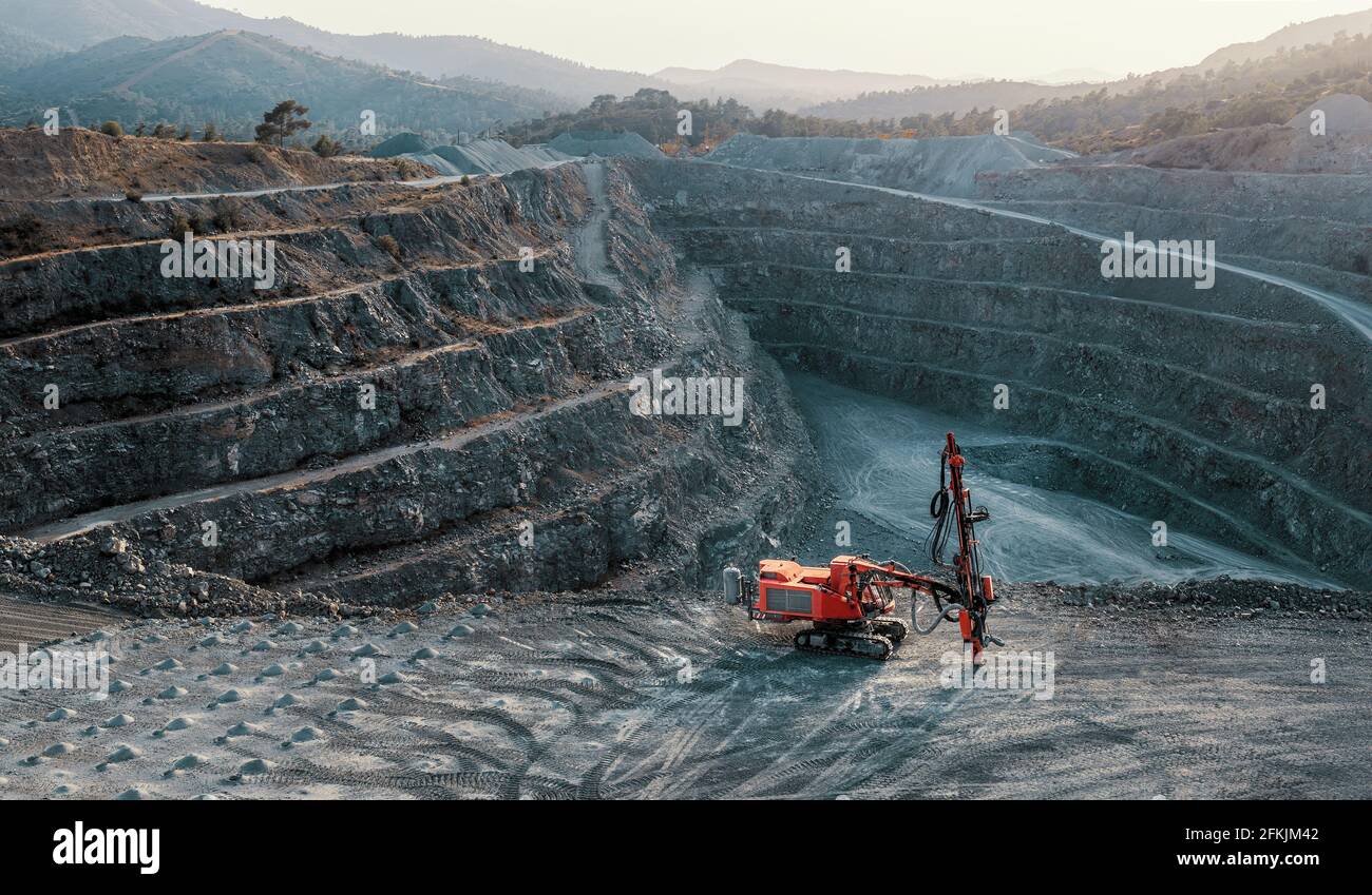 Red stone crusher on a terrace of gravel quarry. Industrial landscape, no people Stock Photo