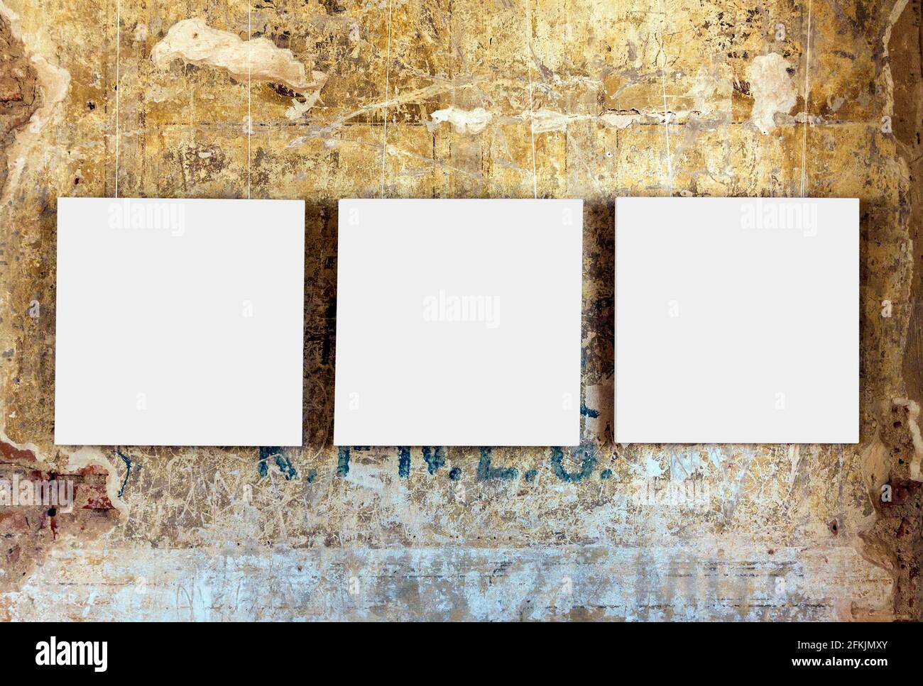 Three empty painting frames on old weathered grunge wall Stock Photo