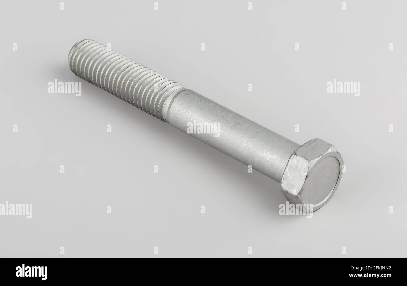Bolt fastening of the tie spring on a gray background. Truck spare parts mounting bolt. Transmission mounting bolt. Stock Photo