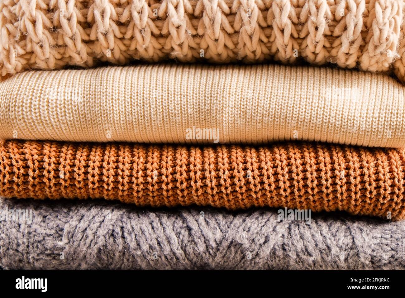 Bunch of knitted warm pastel color sweaters with different knitting