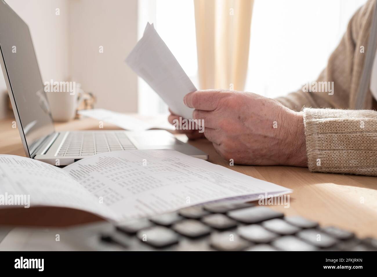 Senior man working out at home in living room, doing yoga exercise on