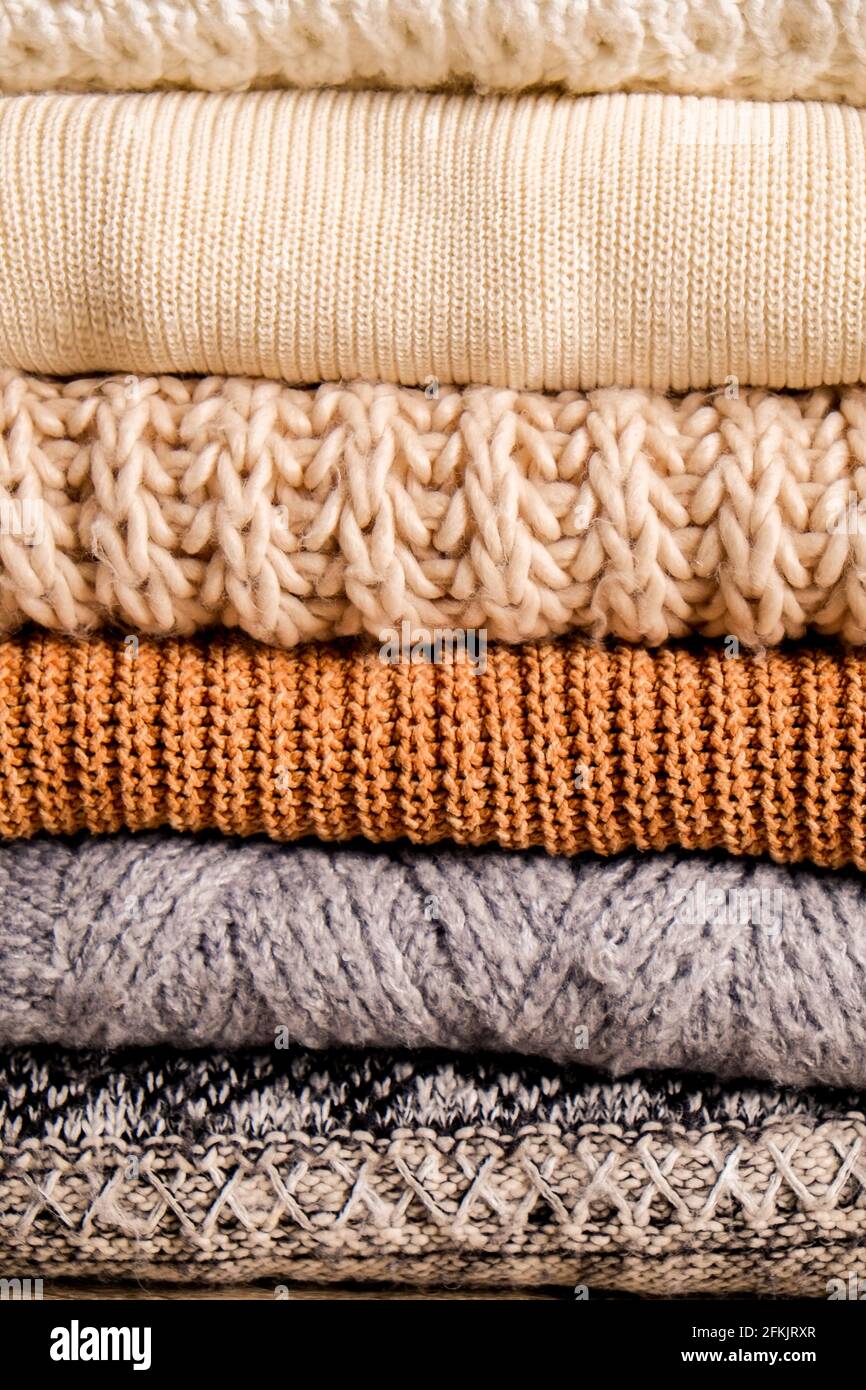 Bunch of knitted warm pastel color sweaters with different knitting