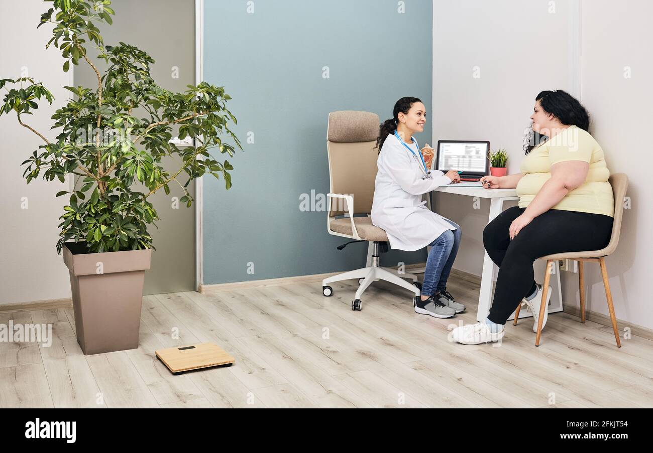 Nutritionist consultation. Dietitian plans a meal plan for a female overweight patient at a diet clinic Stock Photo