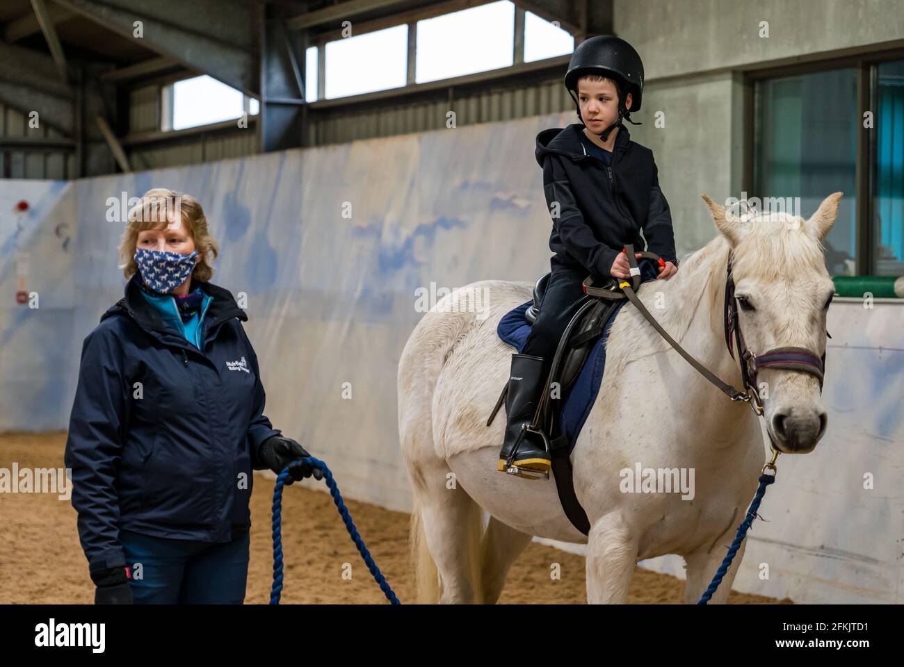 Boy riding horse, Riding for disabled at Muirfield Riding Therapy, East Lothian, Scotland, UK Stock Photo