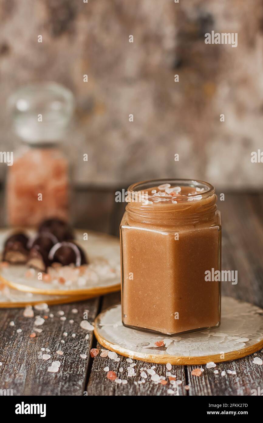 Homemade salted caramel sauce in jar on vintage background Stock Photo