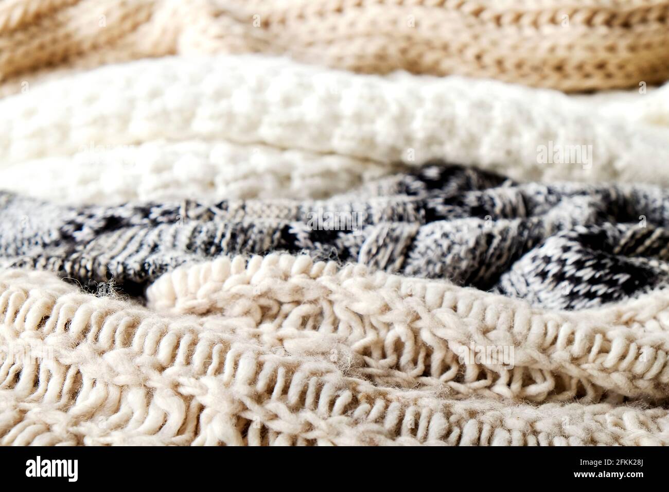 Bunch of knitted warm pastel color sweaters with different knitting