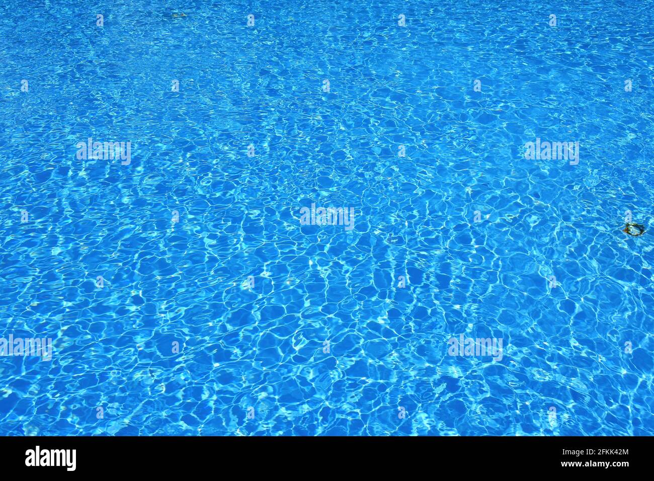 Rippled blue water surface. Water level in the pool. Light reflections on the surface of the water full of ripples. Stock Photo