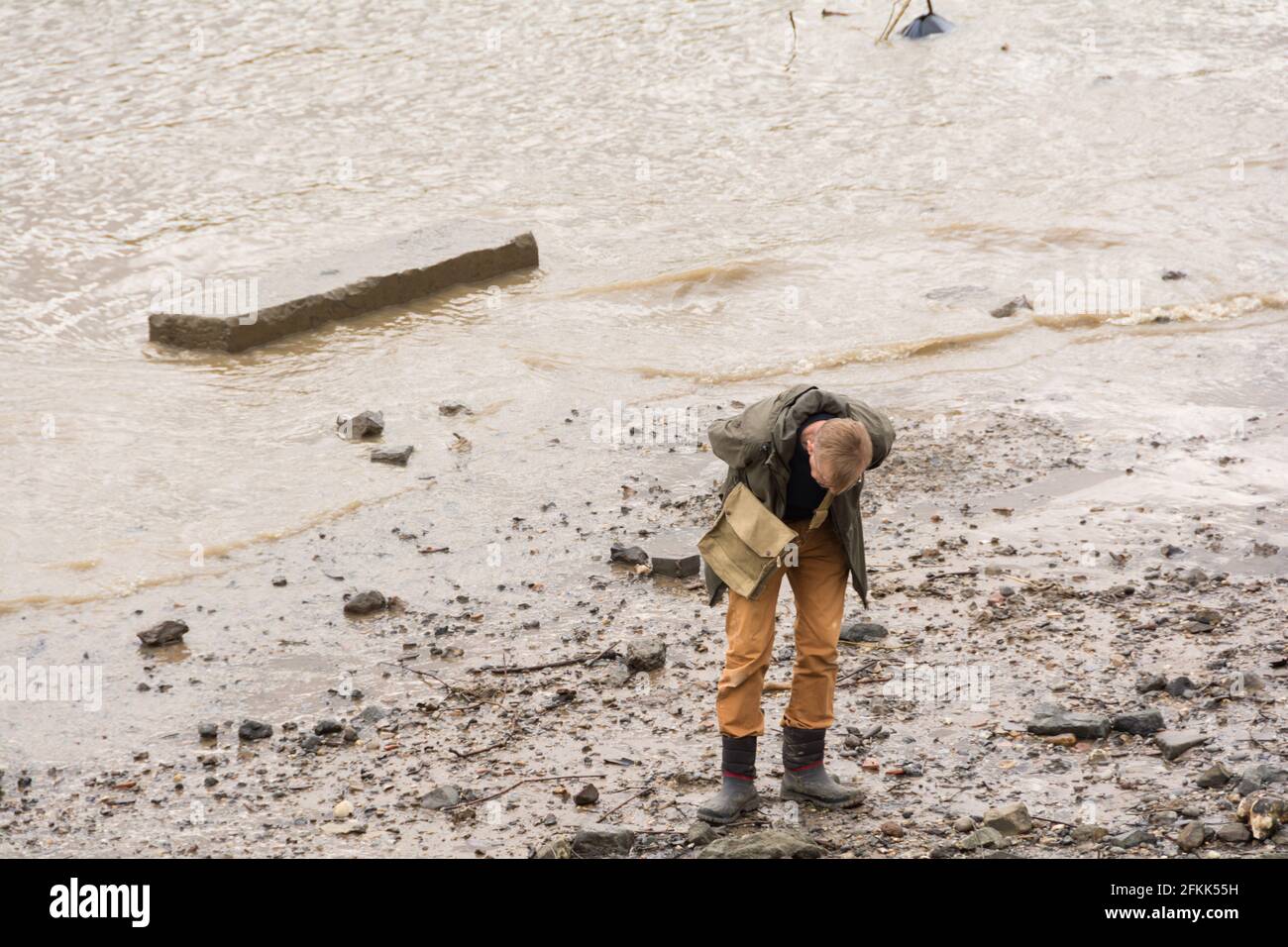A man mudlarking on the River Thames in central London, UK. Stock Photo