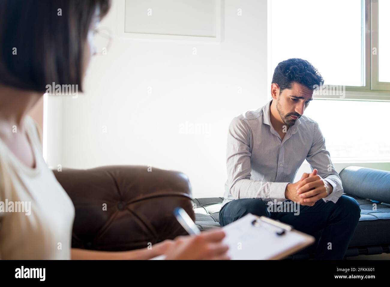 Psychologist taking notes during therapy session. Stock Photo