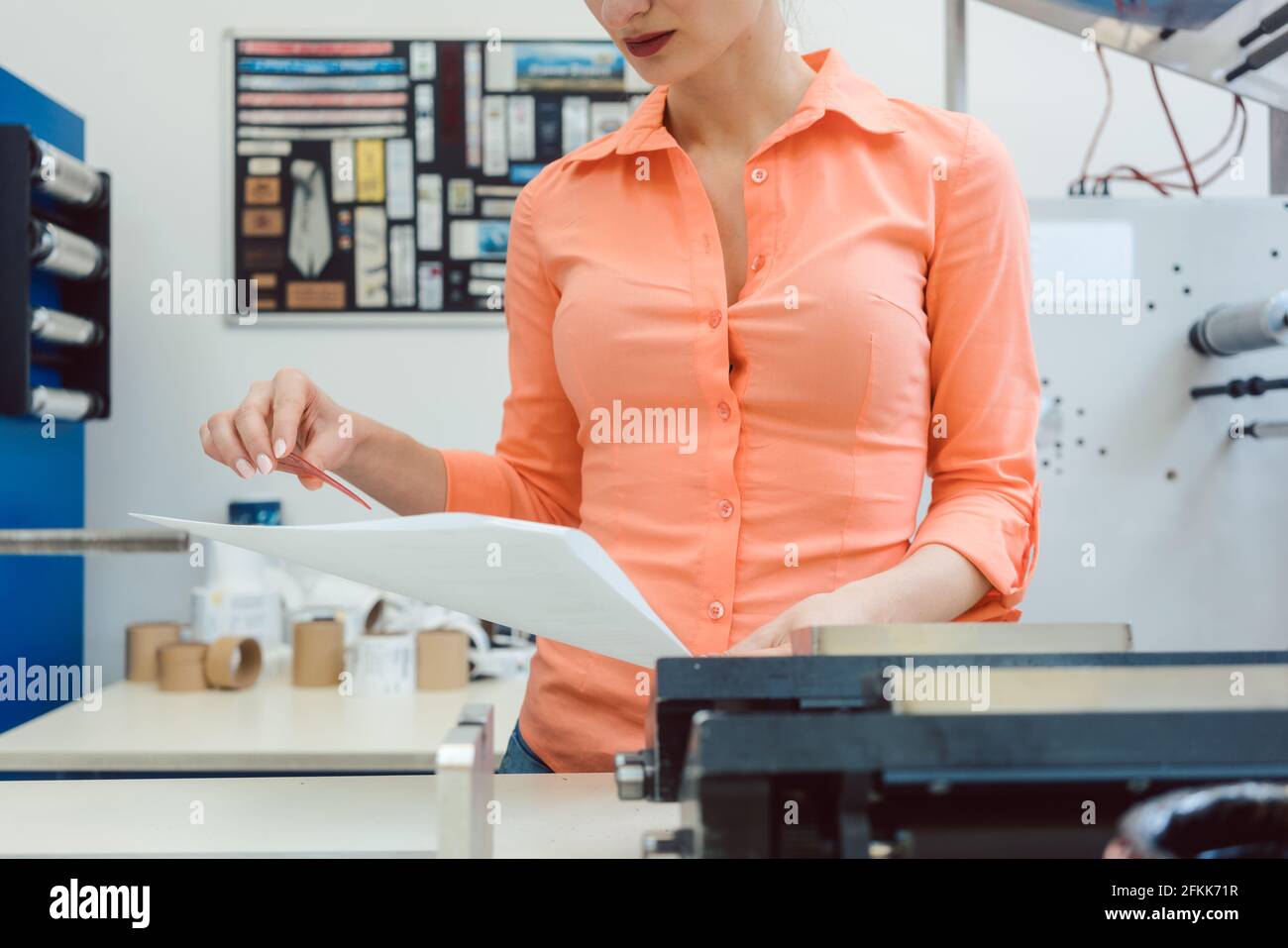 Worker checking design or a print to be run on printing machine Stock Photo