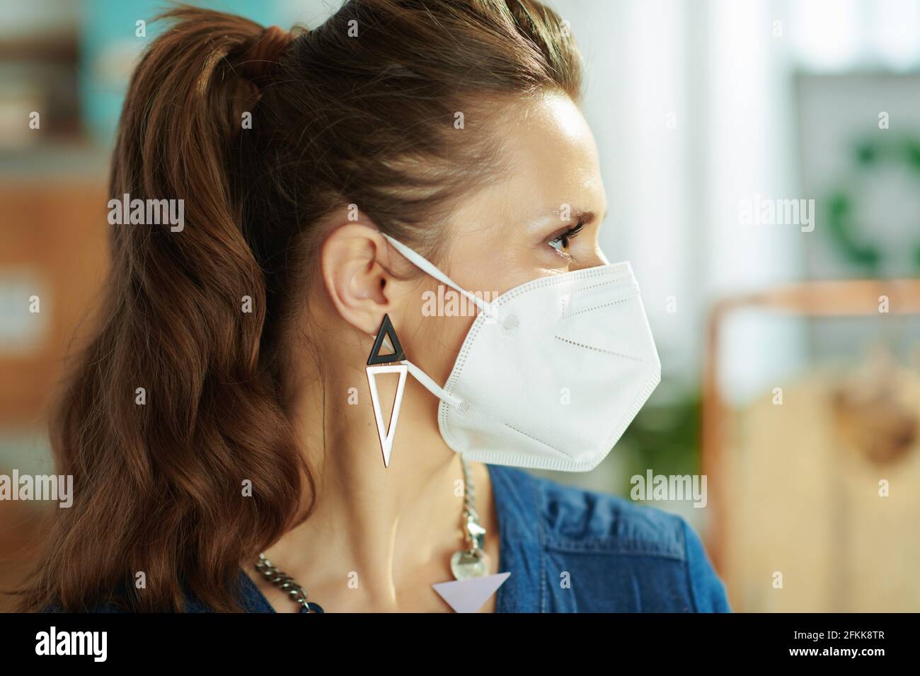 trendy 40 years old small business owner woman with ffp2 mask in the office. Stock Photo