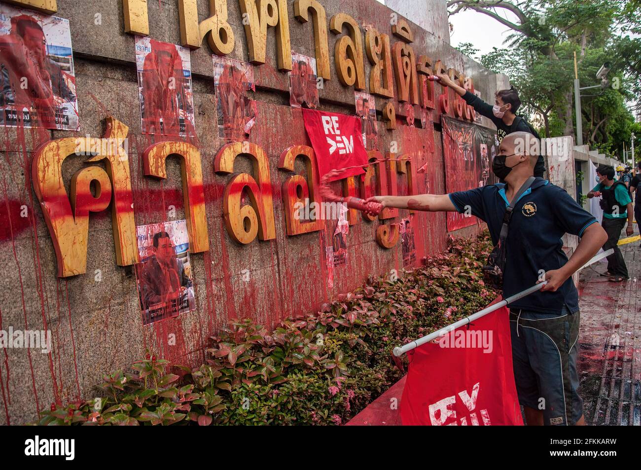 A protester splashes paint at the Criminal Court sign during the demonstration. The pro-democracy protesters led by 'REDEM' group gather at the Victory Monument before going by vehicle to the Criminal Court of Thailand to demand the release of detained pro-democracy activists who were detained by the lese majeste law (article 112 of the Thai criminal code). (Photo by Peerapon Boonyakiat / SOPA Image/Sipa USA) Stock Photo
