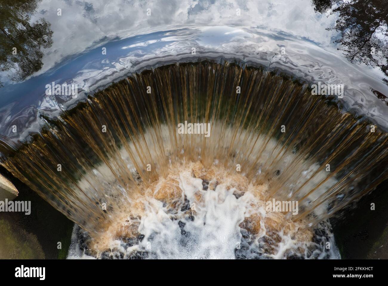 Top view of brown, iron rich water falling over a weir Stock Photo