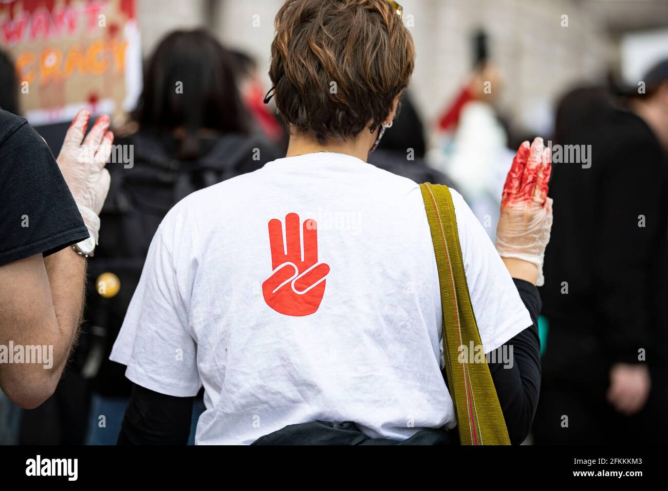 London, UK. 2nd May, 2021. Protesters wearing a T-shirt with three-finger  salute from 'The Hunger Games' during the global Myanmar Spring Revolution,  showing solidarity with Myanmar, as they matching to Trafalgar Square