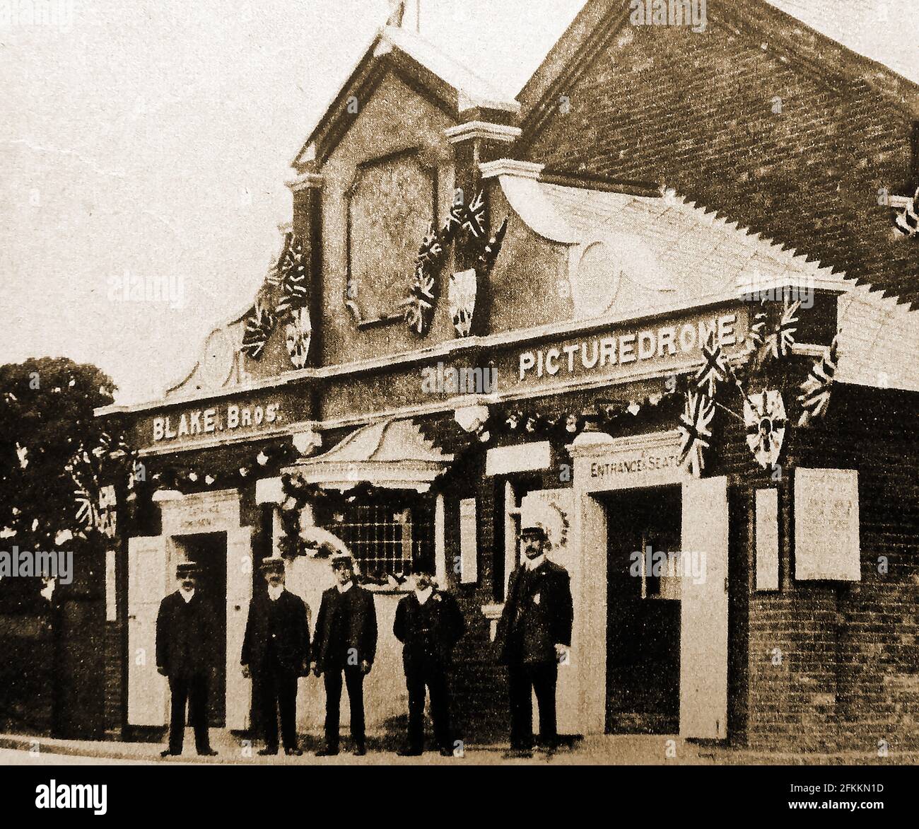 1911 - One of the1st purpose built cinemas in Britain , The Blake Brothers Picturedome at Hitchen Herts, is shown decorated for the coronation of  George V and his wife Mary as king and queen of the United Kingdom (and the British Empire). The brothers had already  opened their first  Picturedrome in Bedford .  Jim and Archie Blake  photographic businessmen chose Hitchen for their second purpose-built cinema. The 400 seat cinema  first opened around March 1911. Stock Photo