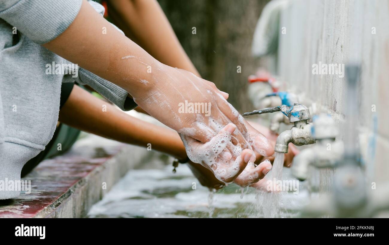 Close up hands of woman use soap and washing hands under the water tap ...