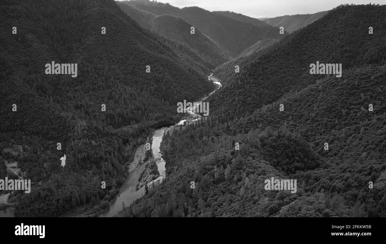 A grayscale of a narrow long river between mountains Stock Photo