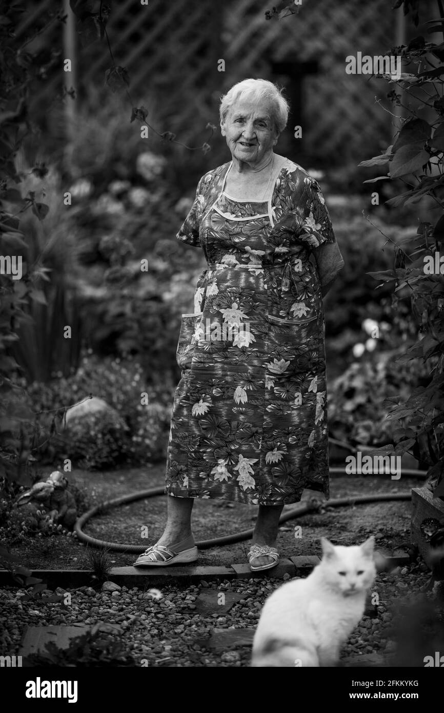 An old woman in the garden with her cat. Black and white photo. Stock Photo