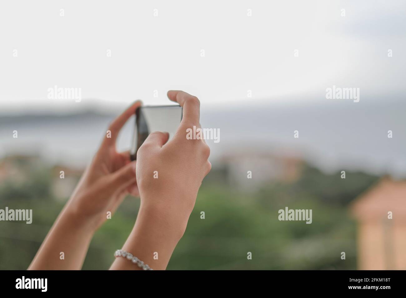 Young woman taking landscape pics with a touch screen smartphone,hi tech device Stock Photo
