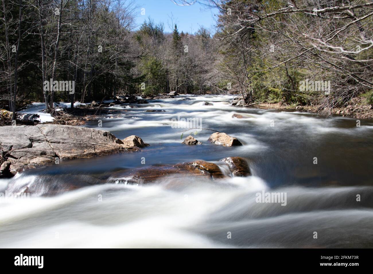 An early spring long exposure view of the Sacandaga River in the Adirondack Mountains, NY wilderness Stock Photo