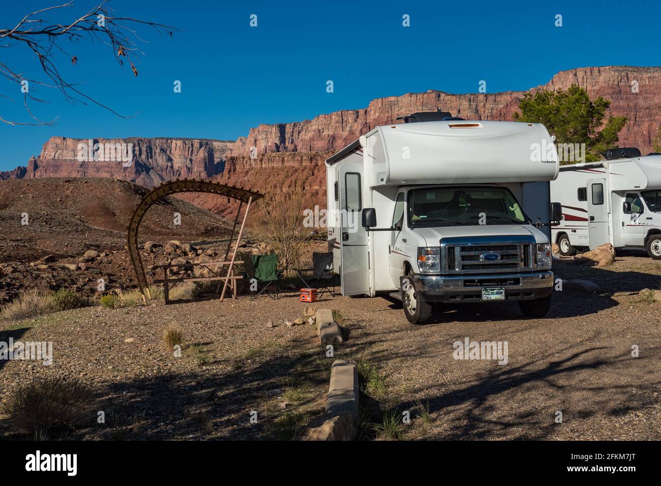 C-type camper with slideouts standing in a wilderness campground in the sun Stock Photo