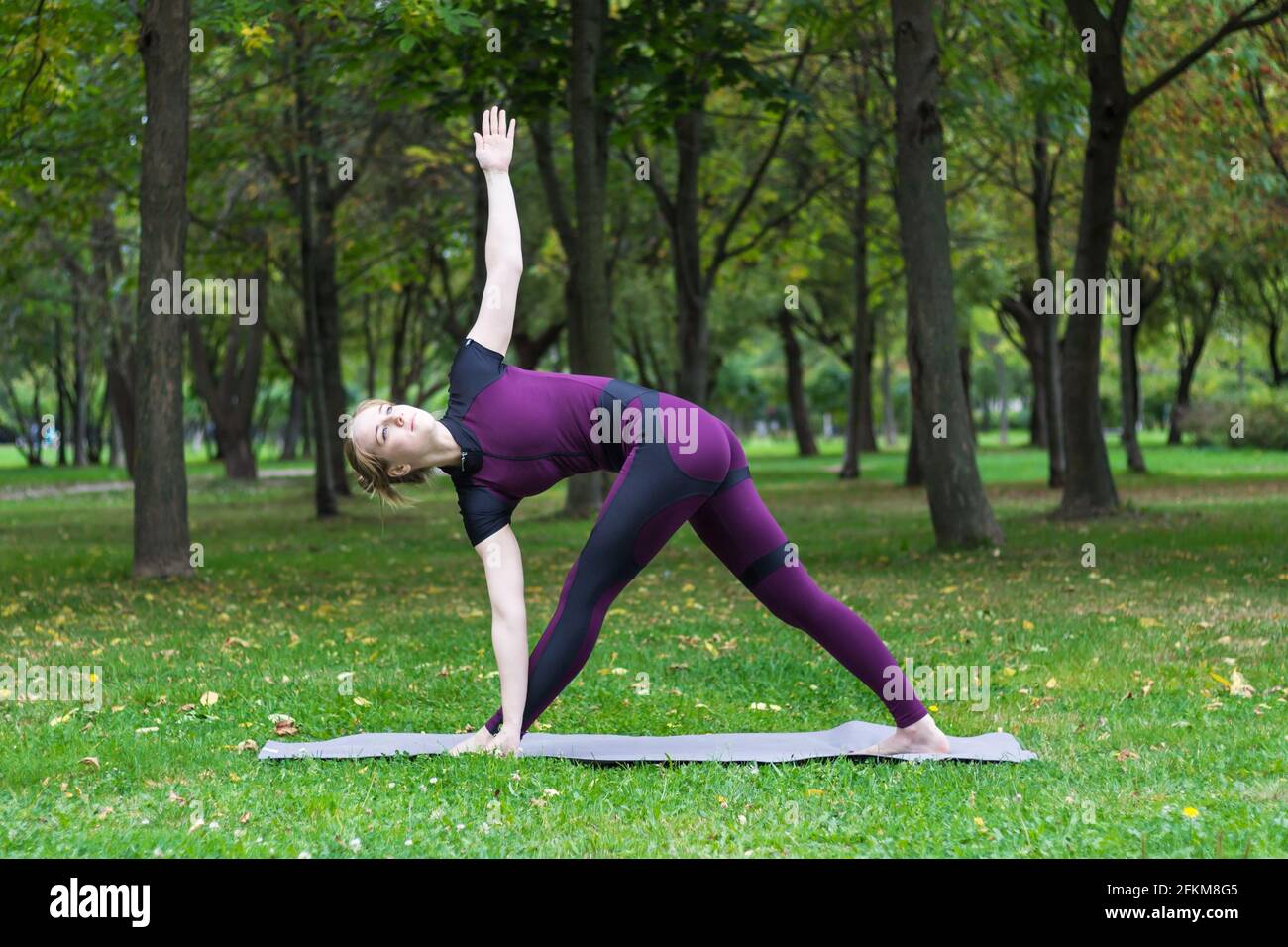 pretty blond young woman practice yoga asana in summer park Stock Photo