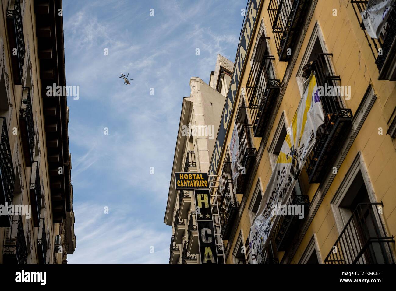 A police helicopter flies over the Hostal Cantabrico on Calle de la Cruz, 3 and 5 "La Ingobernable" which was an occupied and self-managed neighborhood social center. This morning, dozens of activists of La Ingobernable entered illegally and occupied another abandoned building in the Madrid downtown. The building is located on Calle de la Cruz 3 and 5, abandoned since 2016 and owned by the Fernández Luengo brothers, known for their Marco Aldany franchise. Despite the eviction attempts by the Spanish Police, dozens of protesters were able to prevent it. Stock Photo