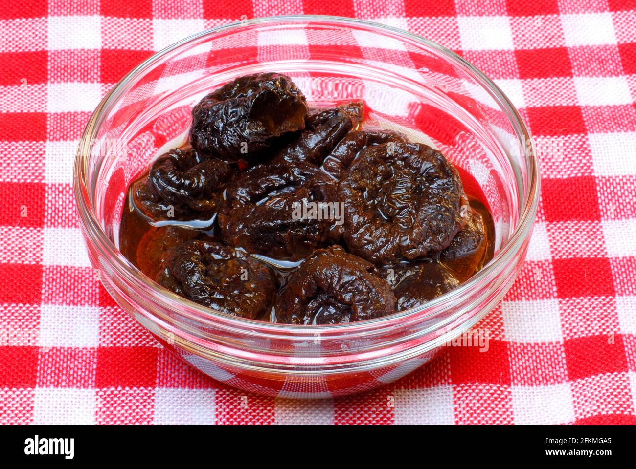 Plums, dried, soaked in water, prune Stock Photo Alamy