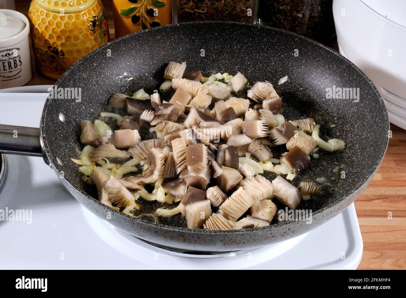 Oysters (Pleurotus ostreatus) are fried in a pan with melted butter
