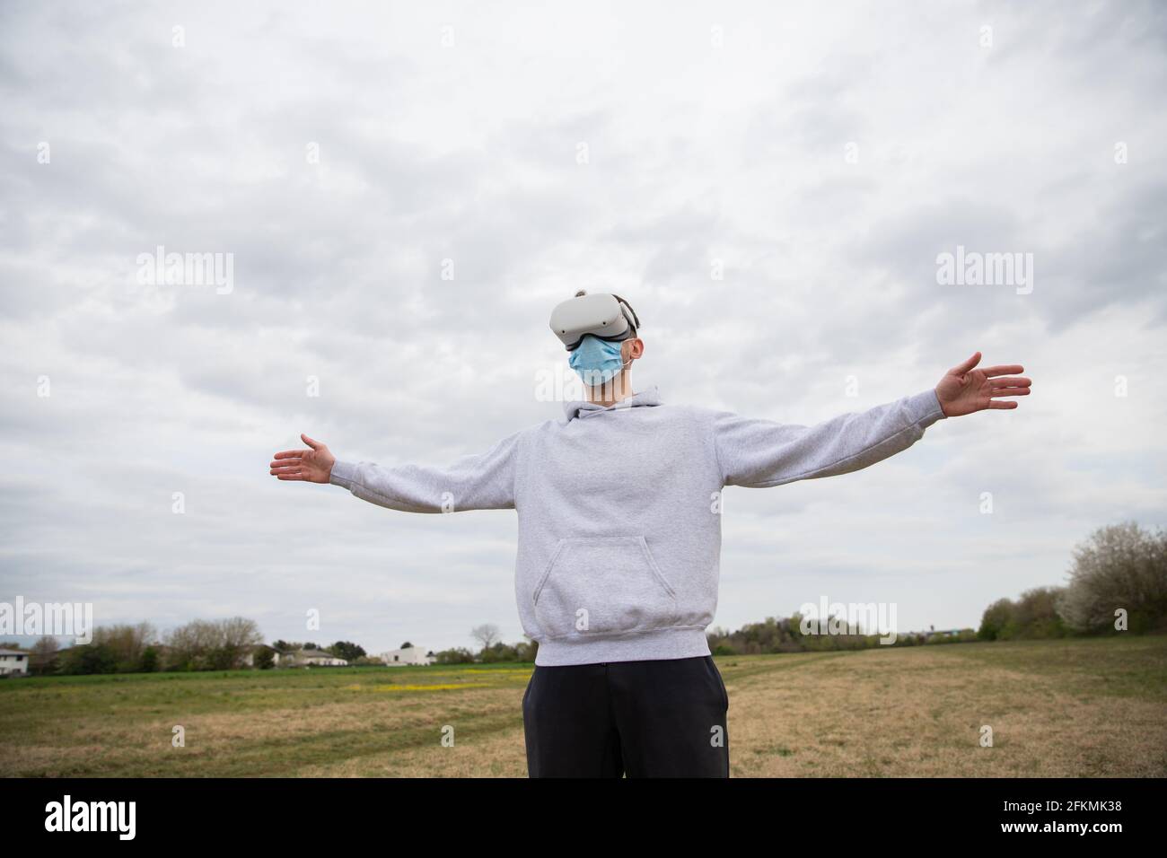 A man has fun using a virtual reality headset outdoors in a field Stock Photo