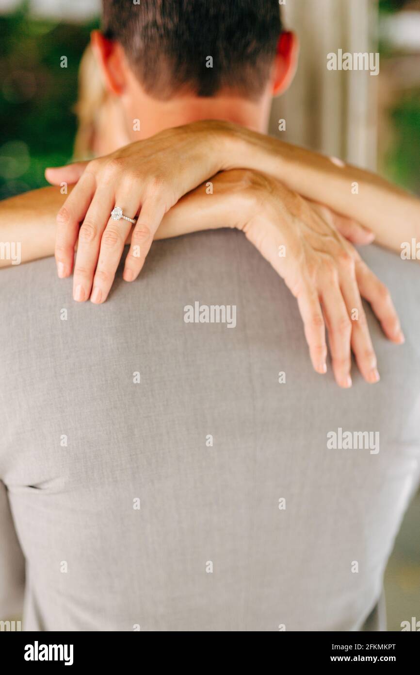The bride and groom hug, the bride wrap her arms around the shoulders