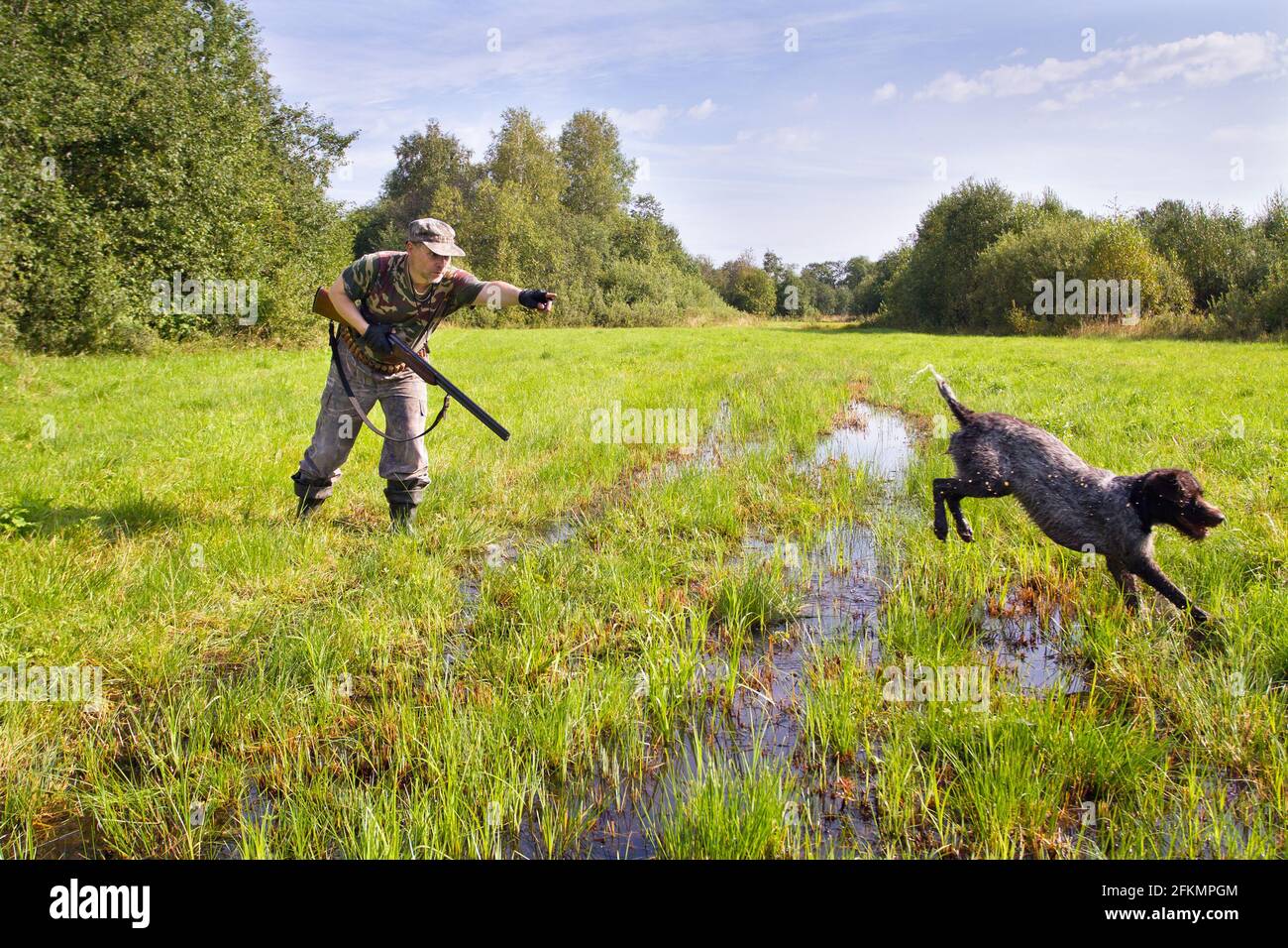 the hunter sends the hunting dog to look for game with a hand gesture Stock Photo