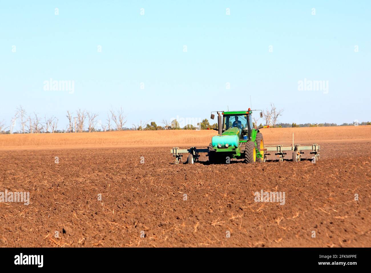 John Deere 8120 tractor plowing a field near Narrabri, NSW, Australia. There is a liquid fertiliser tank on the front of the tractor. Stock Photo