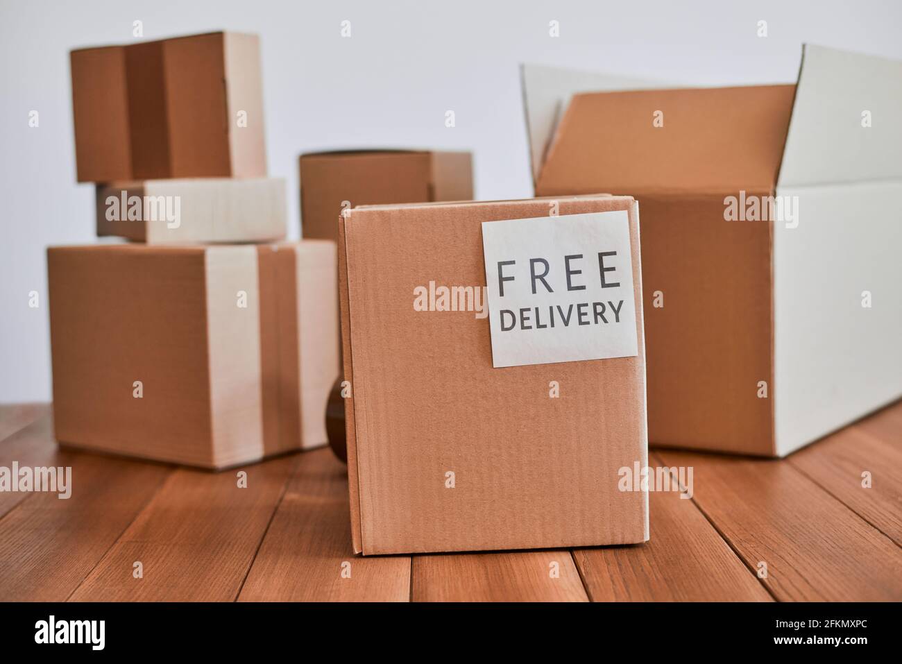 Cardboard box with free delivery label on wooden desk Stock Photo