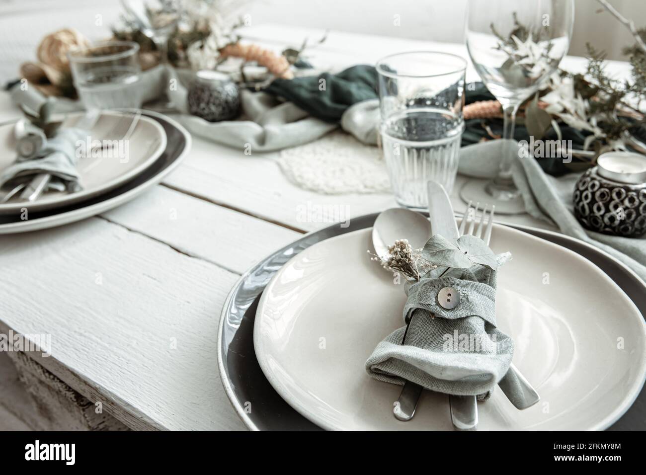 Festive table setting at home with Scandinavian decorative details close up. Stock Photo