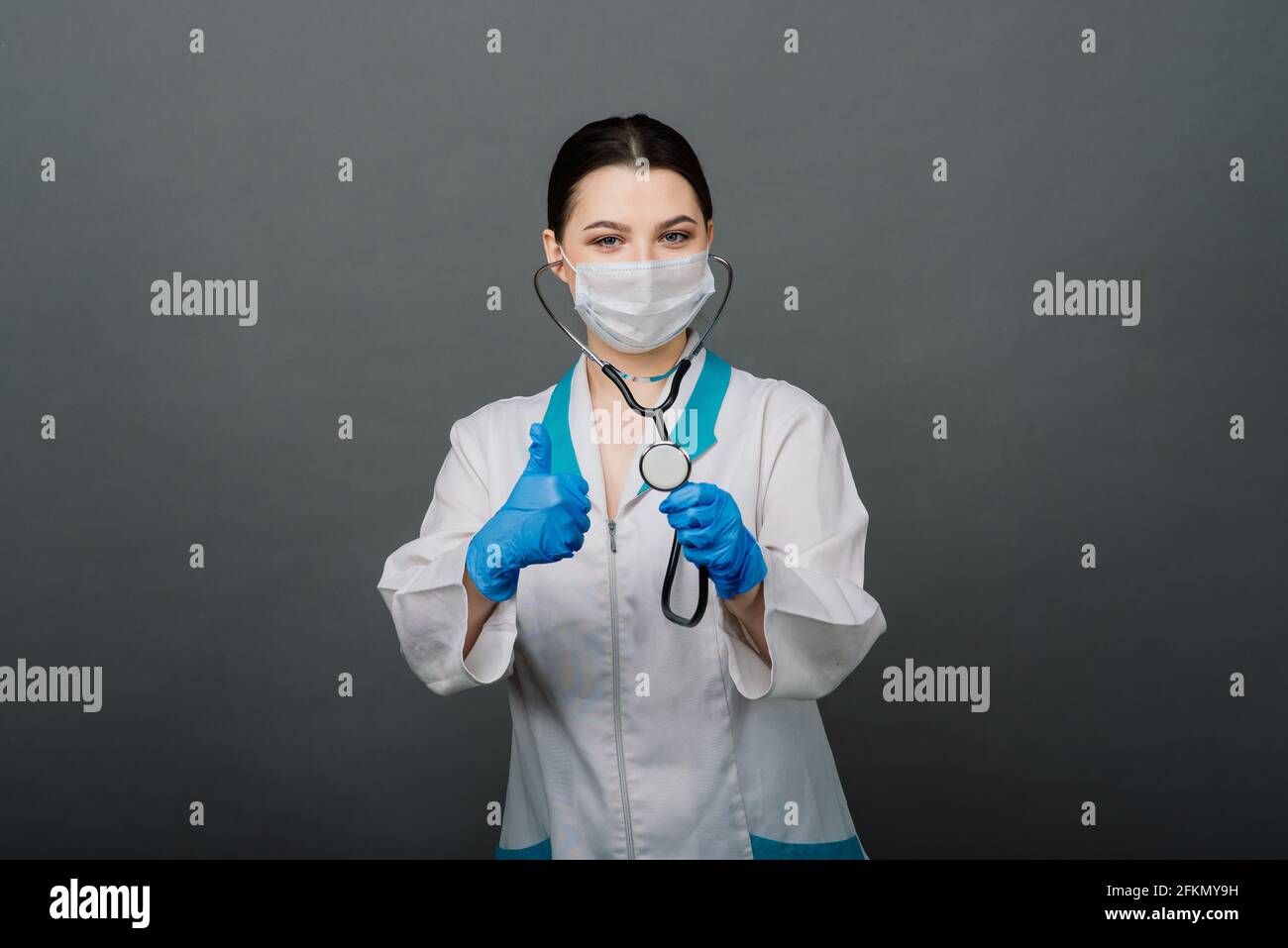 Beautiful female doctor in protective mask looking away and thinking about something. Stock Photo