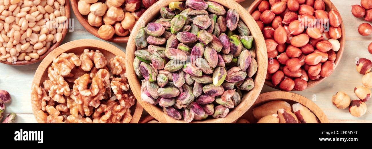 Nuts panorama, overhead flat lay shot. Pistachios, walnuts, peanuts etc Stock Photo