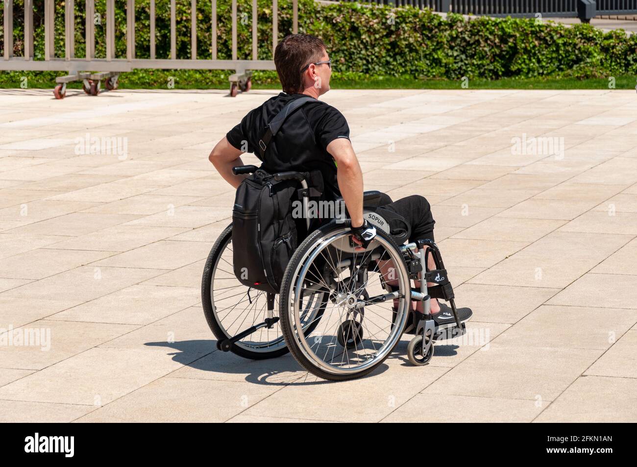 Krasnodar, Russia - May 2 2021: Man in a wheelchair in a park. Sunny day. No Architectural barrier Stock Photo