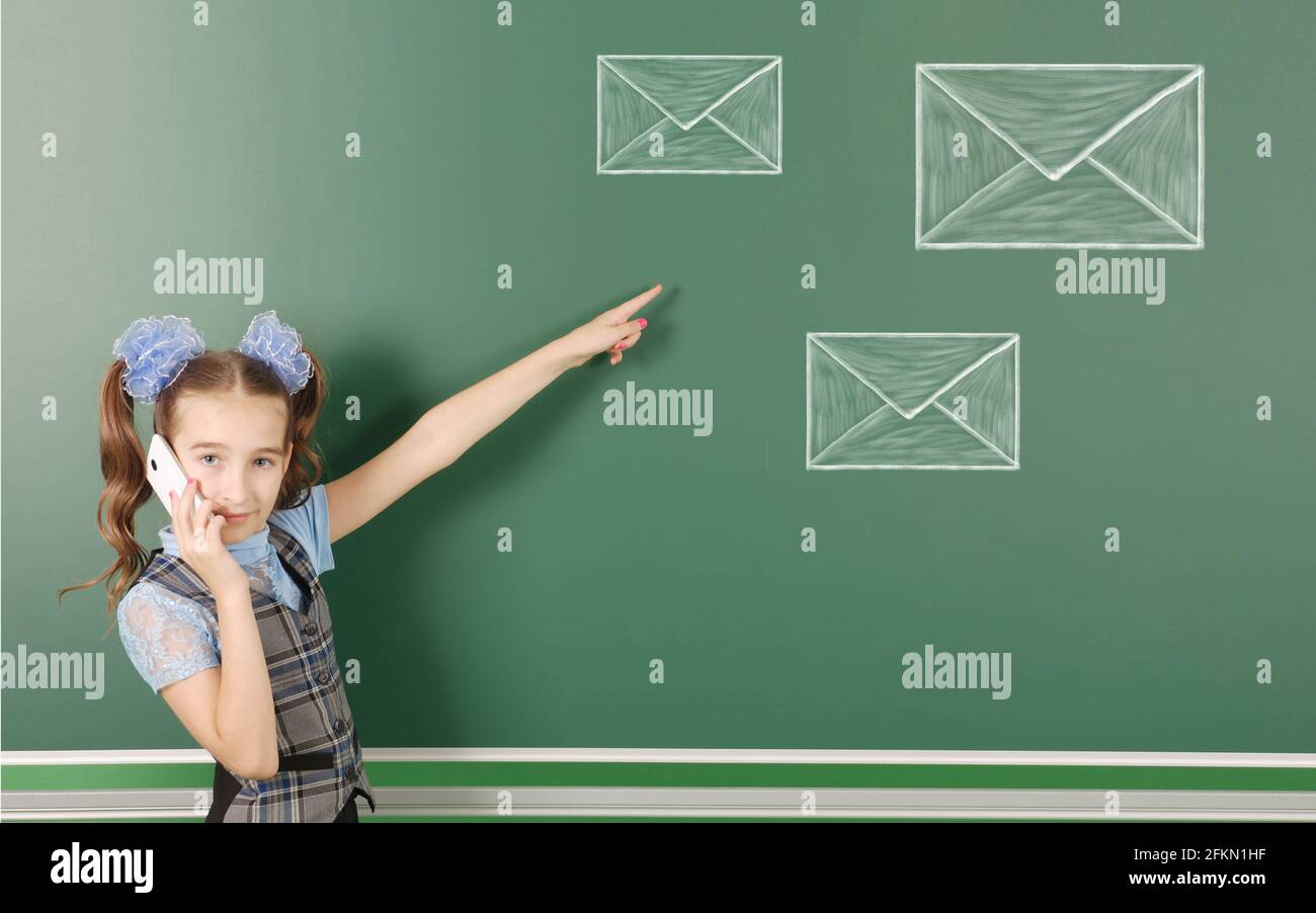 Preadolescent girl checks your email, isolated school board background