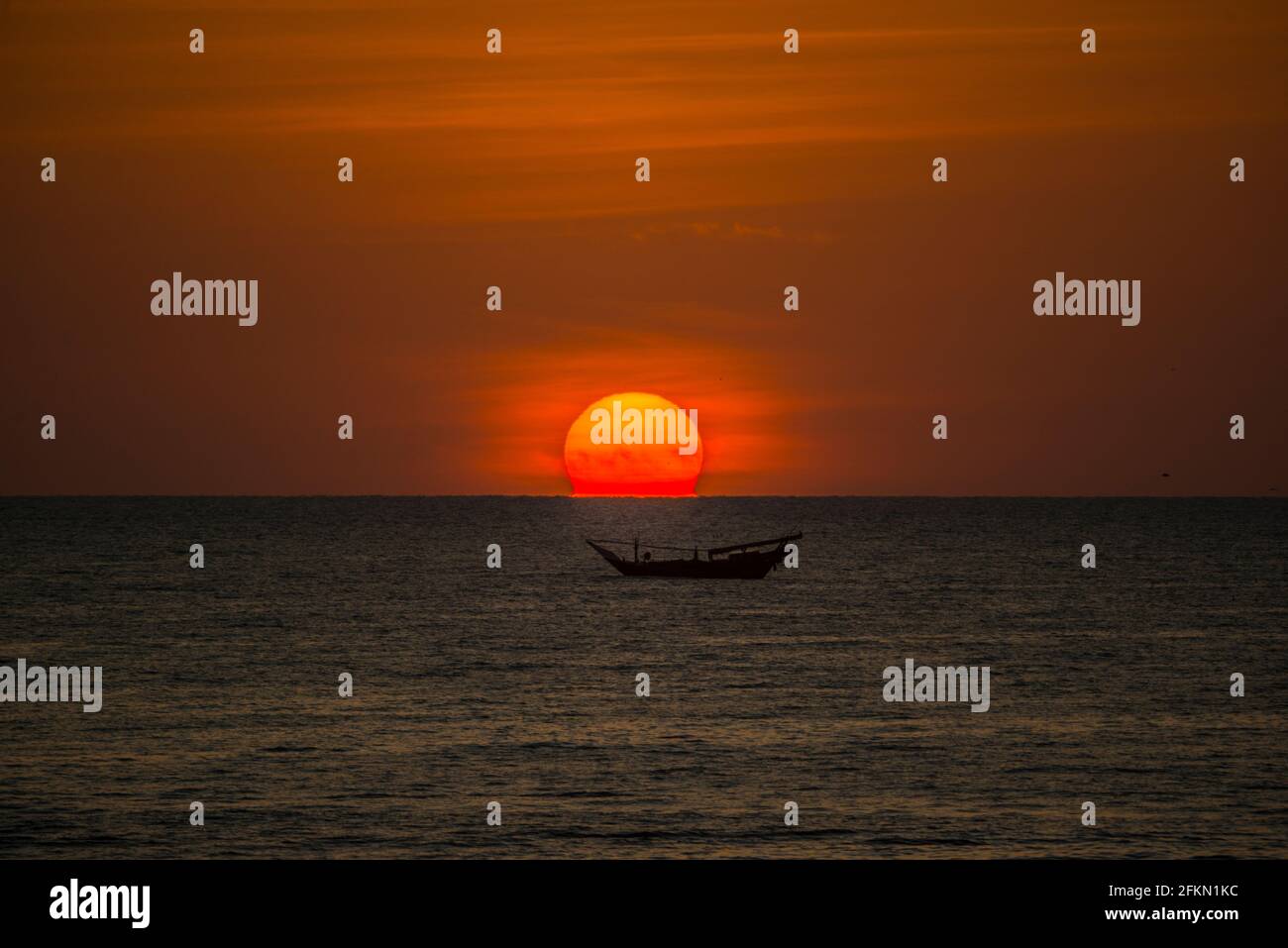 Sunrise, with anchored dhow on the Arabian Sea, Oman Stock Photo