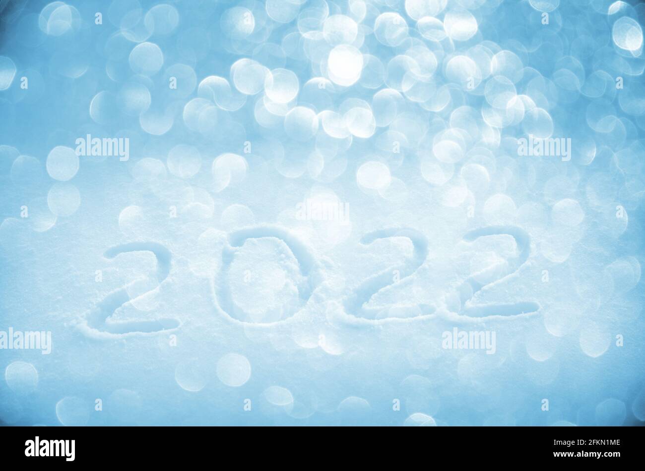 Handwritten digits 2022 on a blue blurred glittering background.New year concept. Stock Photo