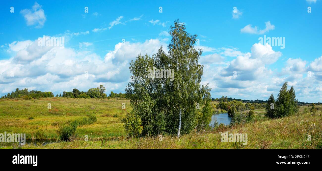 Summer sunny rural landscape with small river and farm fields Stock Photo