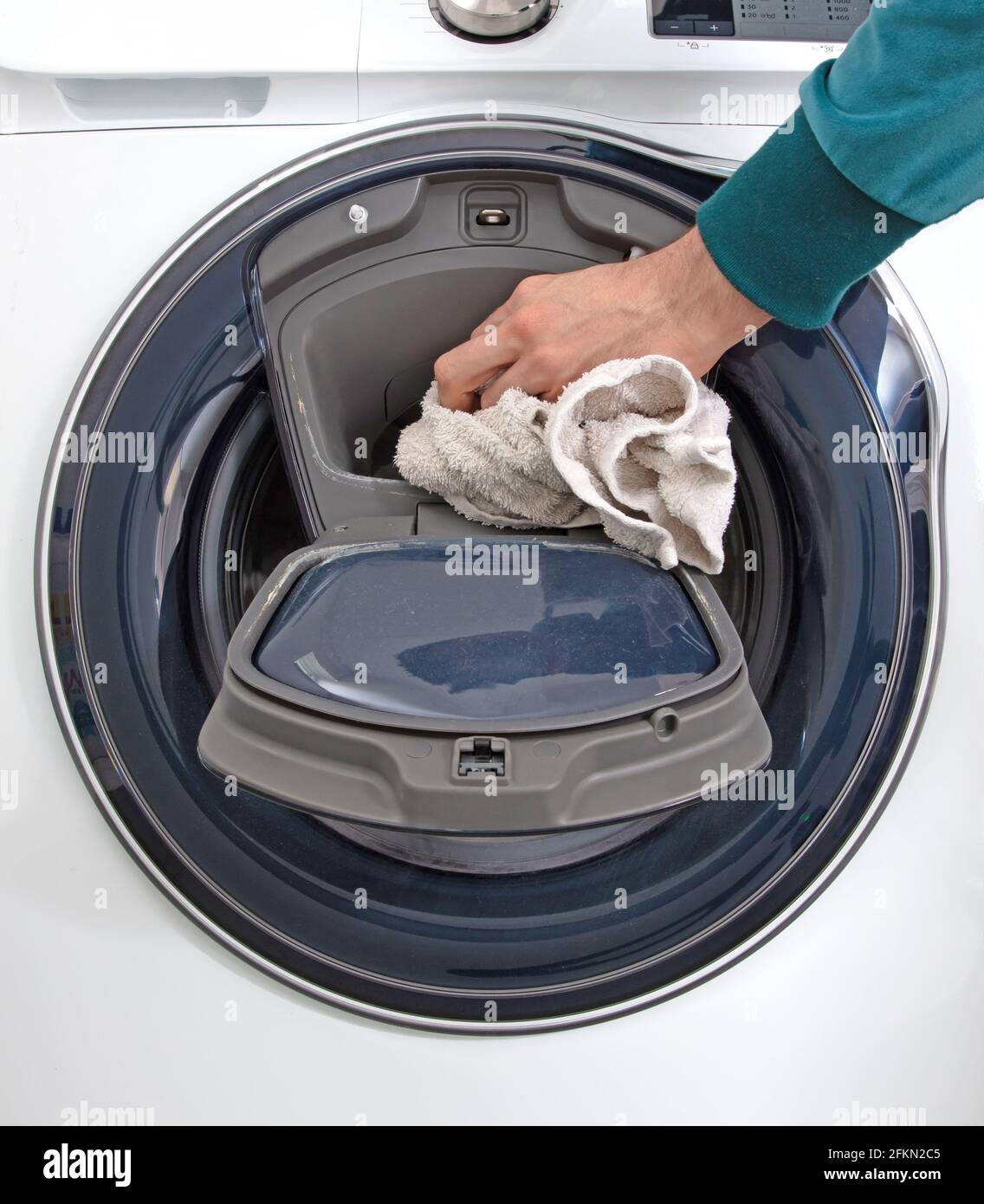 Man filling laundry in the washing machine, cleaning time Stock Photo
