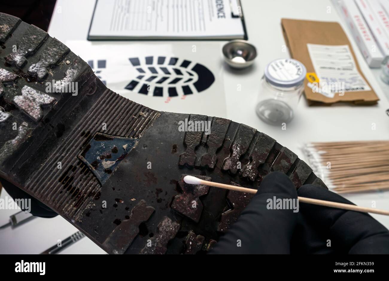 Police scientist taking samples from a shoe sole in a crime lab, conceptual image Stock Photo