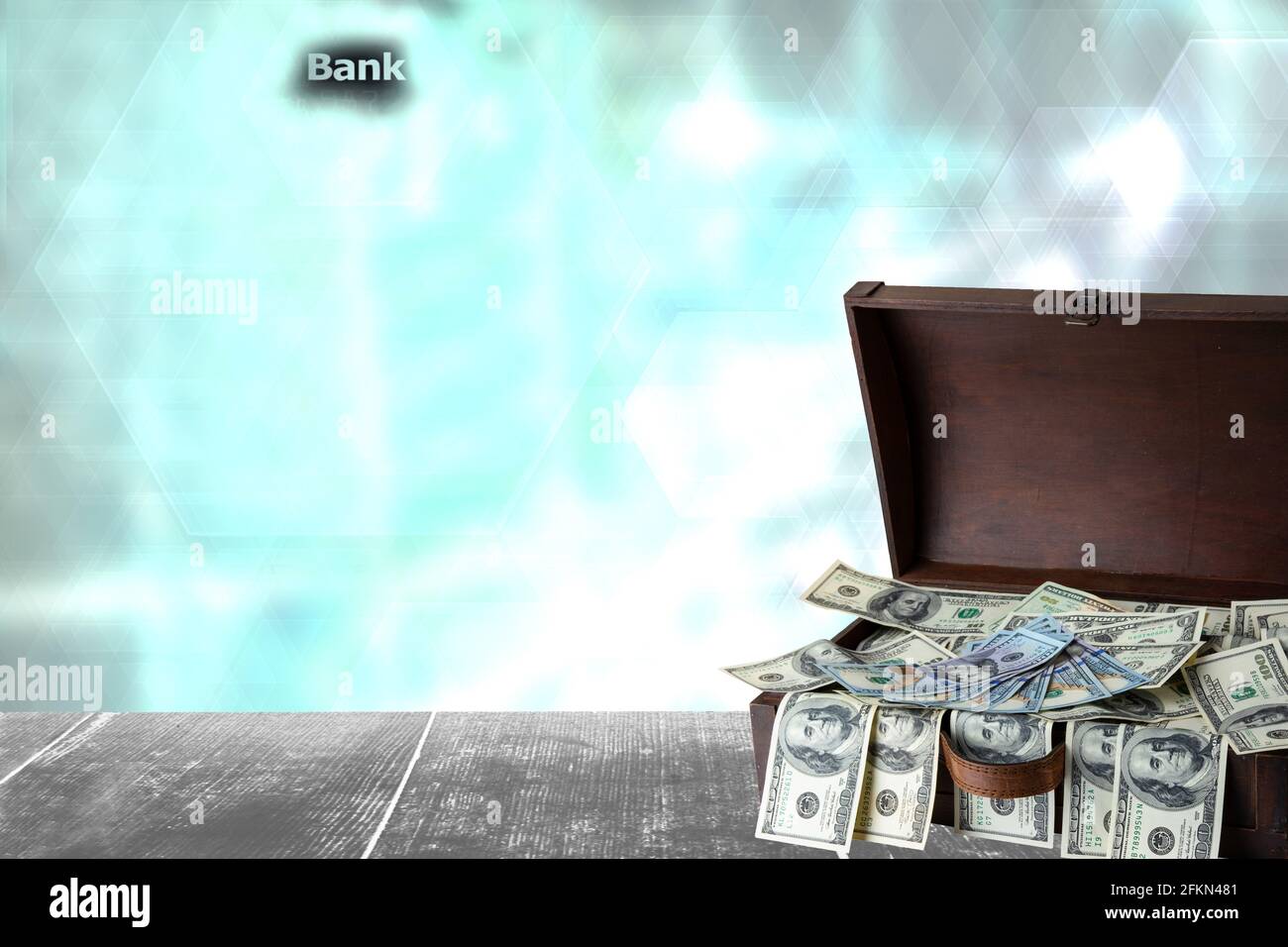 Finance concept. Wooden box full with US 100 dollars on table with abstract blurred bank houses silhouette background.  Concept of money and earnings. Stock Photo
