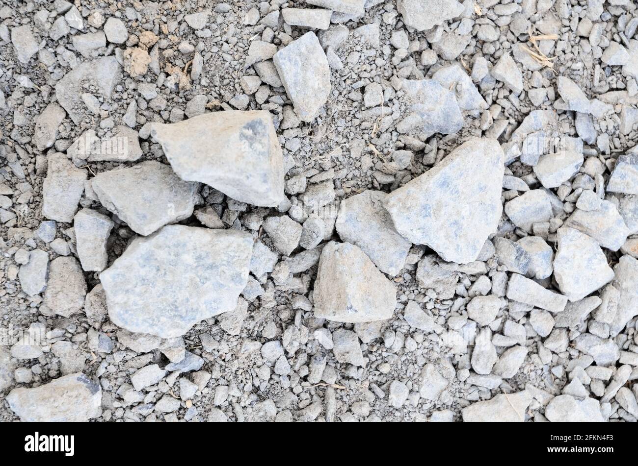 Abstract background with crushed gravel and small little grey rocks and stones, close-up view from directly above Stock Photo