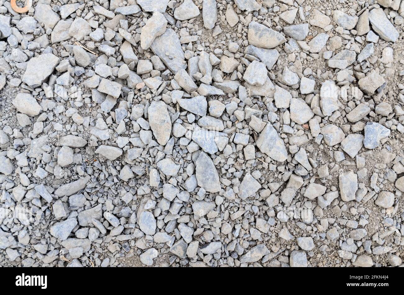 Abstract background with crushed gravel and small little grey rocks and stones, close-up view from directly above Stock Photo