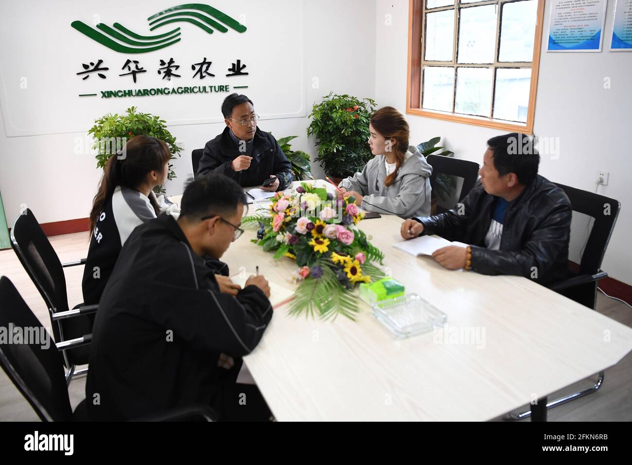 (210503) -- TIANSHUI, May 3, 2021 (Xinhua) -- Zhang Shuhao hosts a meeting with other members of his team at Xinghuarong, an agriculture company in Mudan Township, Tianshui City of northwest China's Gansu Province, on April 27, 2021. Zhang Shuhao, 42, quit his well-paid job three years ago to start an agriculture company with a few partners sharing the same vision at a mountainous village in Mudan Township, Tianshui City. In three years, Xinghuarong, Zhang's company, contracted 6,200 mu (about 413 hectares) of idle arable lands, where terraced fields, greenhouses, and a reservoir have been bu Stock Photo