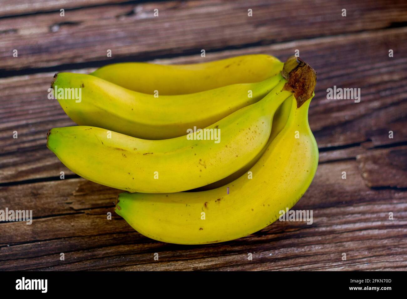 https://c8.alamy.com/comp/2FKN70D/canarian-bananas-on-a-wooden-table-variety-of-bananas-grown-in-the-canary-islands-in-spain-2FKN70D.jpg