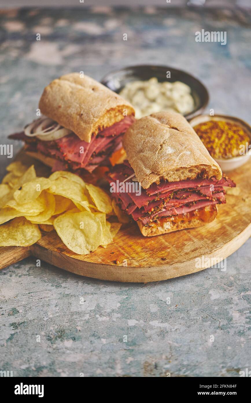 Pastrami sandwhich with delicious meet on baguette bread with chedder